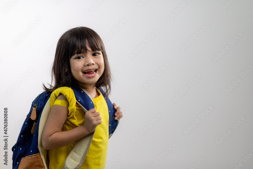 Asian young girl showing her arm with yellow bandage after got vaccinated or inoculation, child immunization, covid delta vaccine concept Asian young girl showing her arm with yellow bandage after got vaccinated or inoculation, child immunization, covid delta vaccine concept