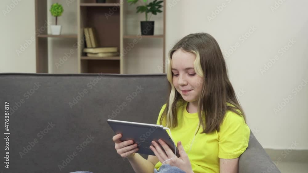 A little girl watches cartoons on a tablet A little girl watches cartoons on a tablet