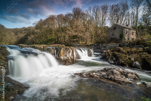 Cenarth Falls, Pembrokeshire. An autumn day, the waterfall is full. Slow shutter speed to smooth out the water photo