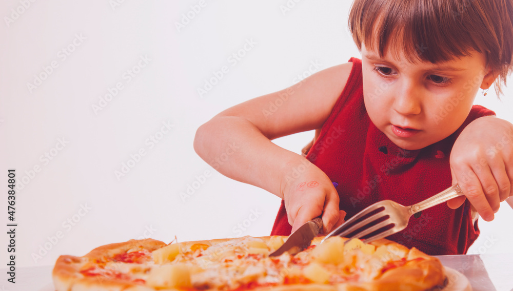Beautiful child girl enjoys delicious slice of pizza, likes this taste. Copy space.