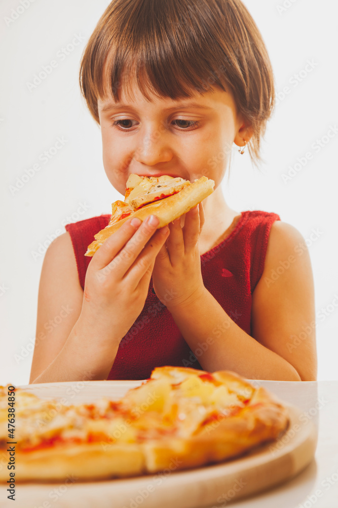 Beautiful child girl enjoys delicious slice of pizza, likes this taste, she has good appetite. Vertical image Beautiful child girl enjoys delicious slice of pizza, likes this taste, she has good appetite. Vertical image