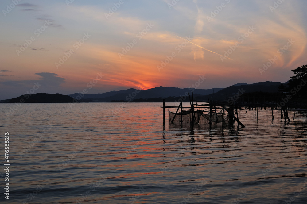夕焼け空と夕焼けの赤が映るさざ波の海面 夕焼け空と夕焼けの赤が映るさざ波の海面