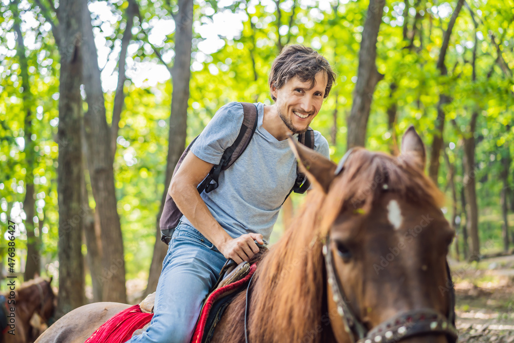 handsome man ride on the black horse in green forest handsome man ride on the black horse in green forest