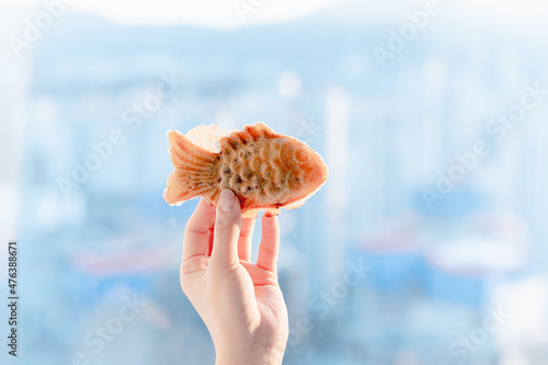 Hands holding fish-shaped buns, Korean winter food. photo
