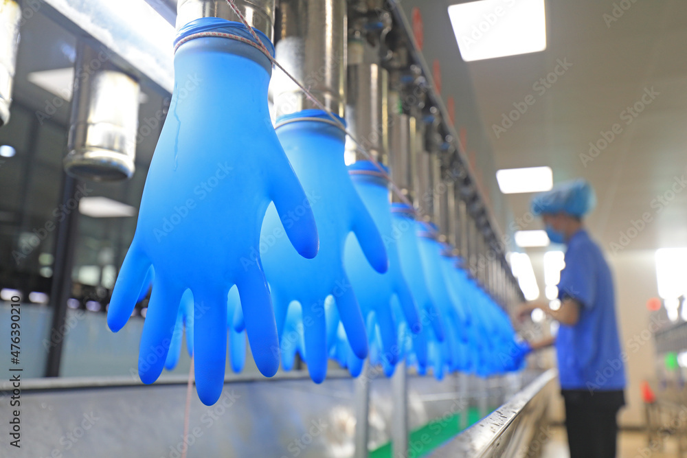 workers spot check the product quality of nitrile gloves on the production line, China