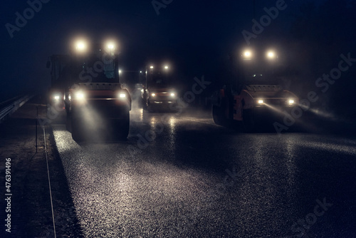 Rolling asphalt at night with headlights. Road construction. © Andrii