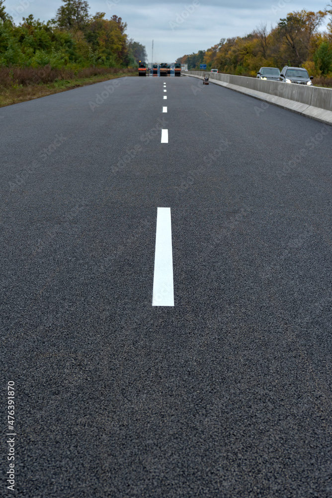 Road marking on the new asphalt on new road. Road construction.