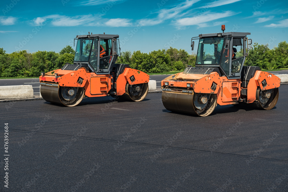 Rollers rolling fresh hot asphalt on the new road. Road construction. Rollers rolling fresh hot asphalt on the new road. Road construction.