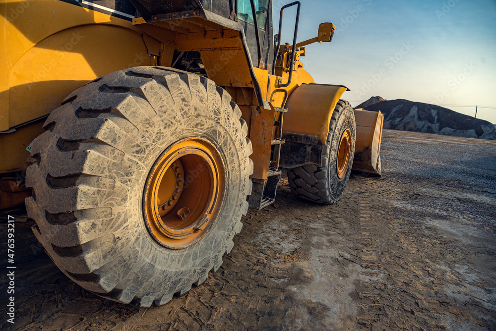 Industrial loader with bucket on the background of crushed stone Industrial loader with bucket on the background of crushed stone