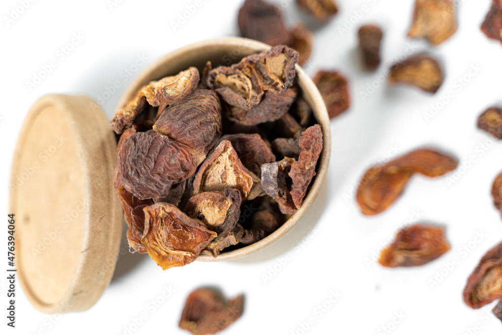 Obraz premium Dried apricots in a paper cup with a lid over white background. Top view.
