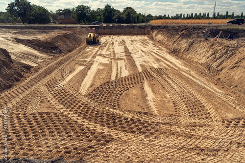 Valokuva The vibratory roller compacts the soil in the excavation