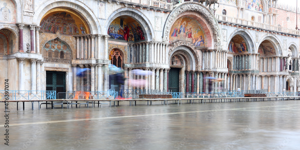 Pedestrian walkways in front of the Basilica of St. Marks square flooded during high tide on the Italian island of Venice