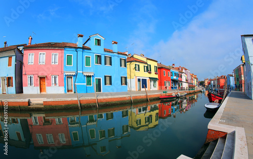 colorful houses on the island of Burano near Venice in Northern Italy and the canal with the reflections