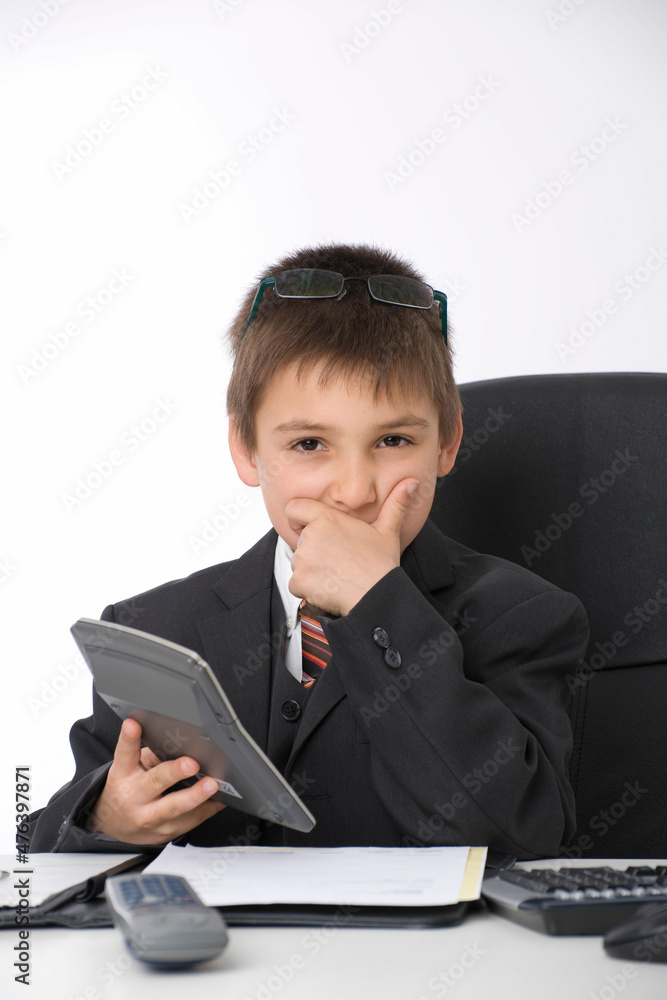 Kleiner Geschäftsmann sitzt am Schreibtisch Kleiner Geschäftsmann sitzt am Schreibtisch
