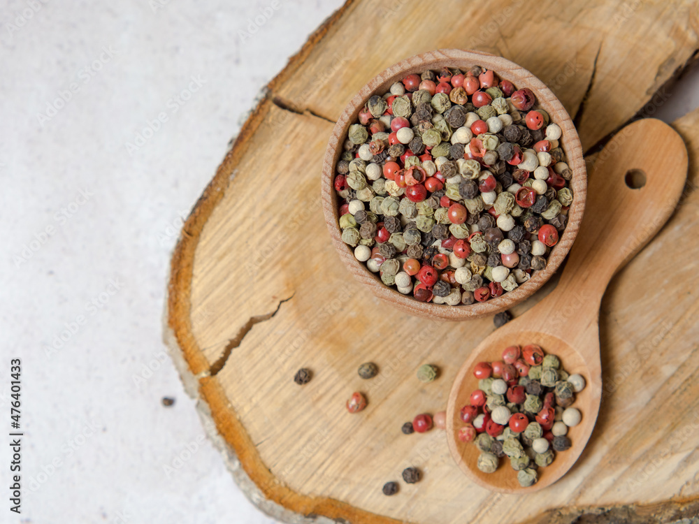 Pepper mix. Black, red, green, white peppercorns spices, Mix of different peppers in a wooden spoon Pepper mix. Black, red, green, white peppercorns spices, Mix of different peppers in a wooden spoon