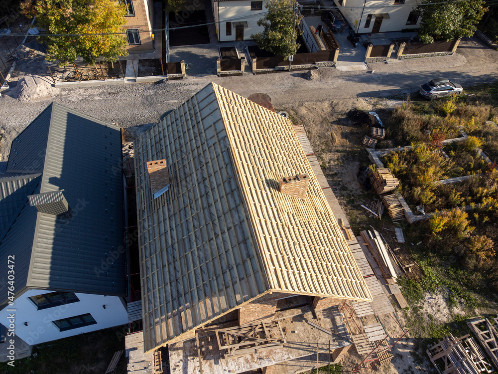 Roof under constructions with lots of tile and red brick chimney