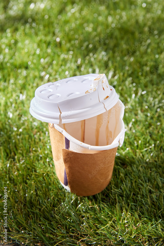 recycling, garbage disposal, environment and ecology concept - close up of used disposable coffee cup on grass recycling, garbage disposal, environment and ecology concept - close up of used disposable coffee cup on grass