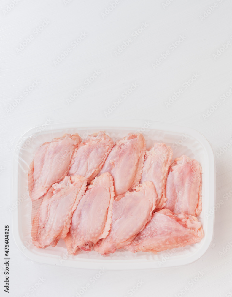 The chicken wings are in a plastic box. The chicken wings are in a plastic box.