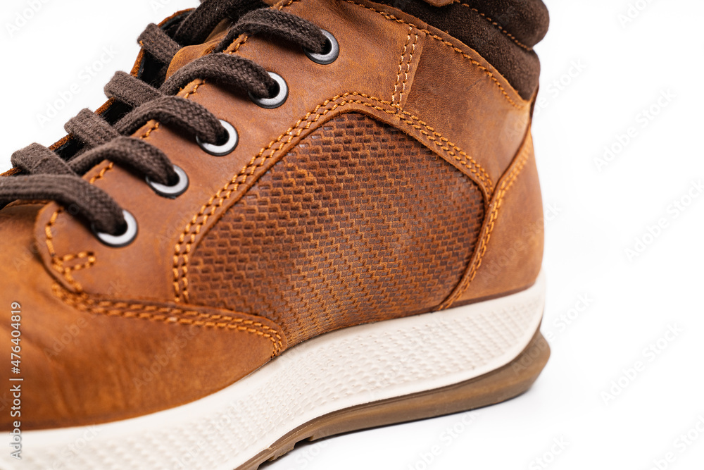 part of brown leather winter boots with lacing on a white background part of brown leather winter boots with lacing on a white background