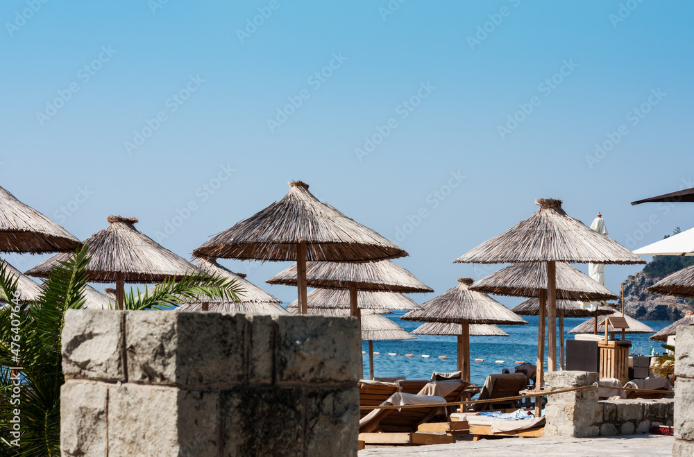 beach hut with umbrellas near Old Town Budva in Montenegro, Europe, Adriatic Sea and mountains,