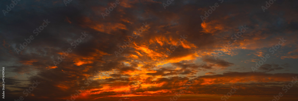 Panorama Sunset with clouds, in orange and colorful shades,World Environment Day concept: Fiery orange sunset sky with dark clouds.Abstract dark background.