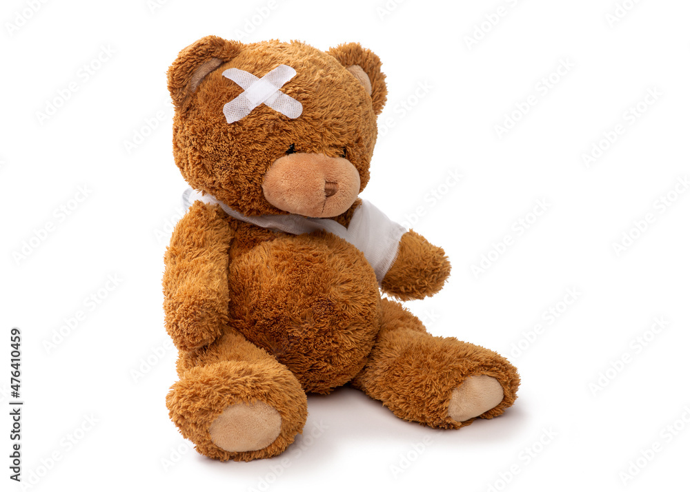 Obraz premium medicine, healthcare and childhood concept - teddy bear toy with bandaged paw and patch on head on white background