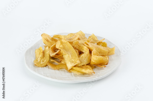 Heap of dried banana chips snack on white background. Selective focus image, blurred background.