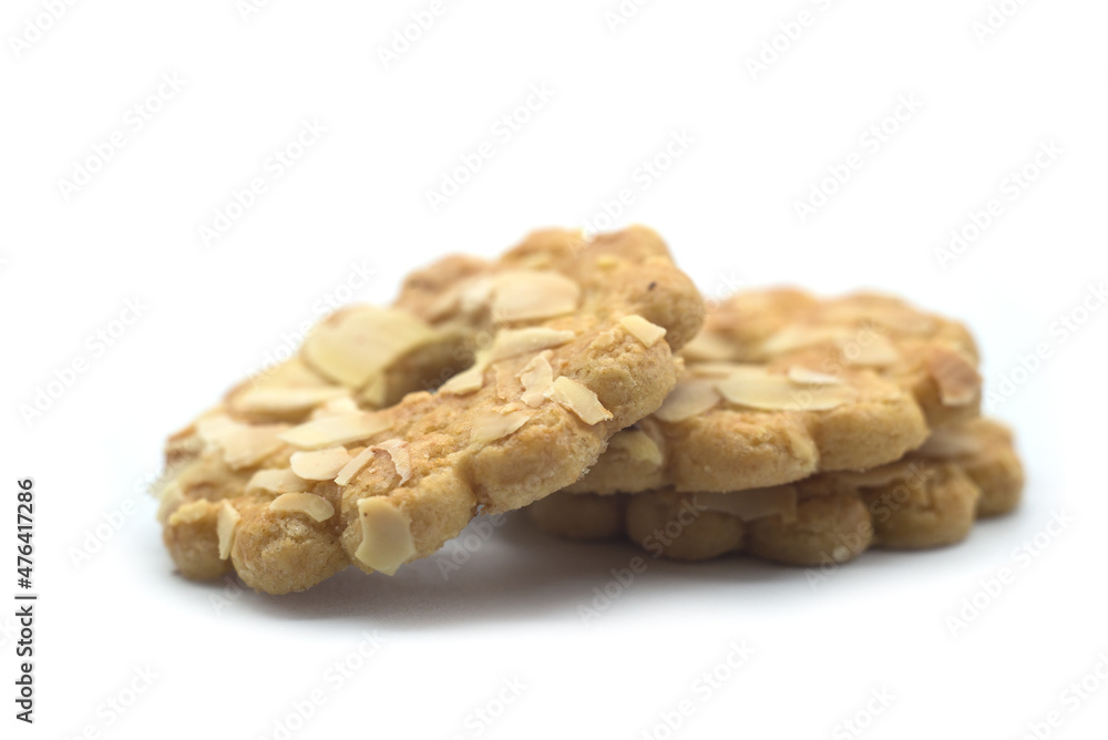 closeup of circle biscuits covered by almonds on white background closeup of circle biscuits covered by almonds on white background