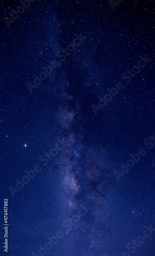 Vertical shot of blue night sky milky way and star on dark background.with noise and grain.Photo by long exposure and select white balance. © noon@photo