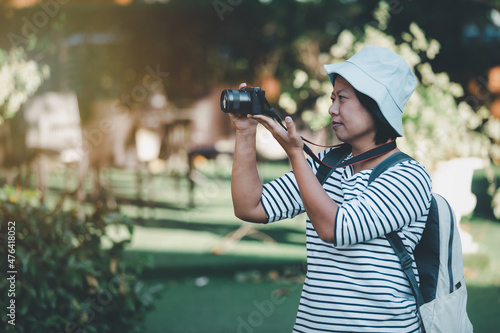 Asian woman taking picture photo with digital camera in city, Tourist asian female smiling using camera to take photograph on travel vintage piture style, lifestyle holiday travel on city streets.