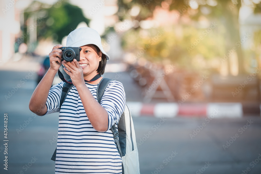 Portrait of asian female happy smile photographer using a camera city streets, Asian woman traveling and taking pictures outdoors vintage image style, business travel concept.