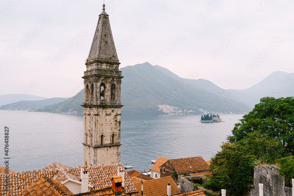 Bell tower of the Church of St. Nicholas on the background of the sea and mountains. Montenegro