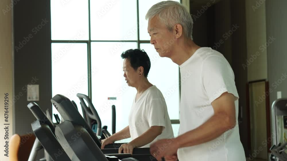 Asian senior couple exercise walking on threadmill together urban returement healthy lifestyle Asian senior couple exercise walking on threadmill together urban returement healthy lifestyle