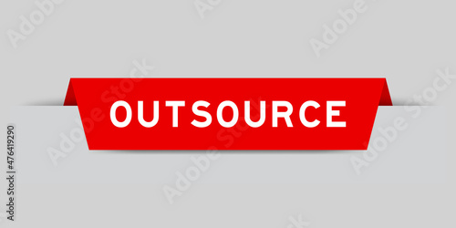 Red color inserted label with word outsource on gray background