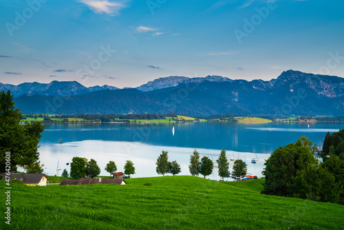 Obraz na płótnie Germany, Allgaeu, Boats and sailing ships on silent water of forgensee lake with spectacular alps panorama at sunset in summer atmosphere w salonie