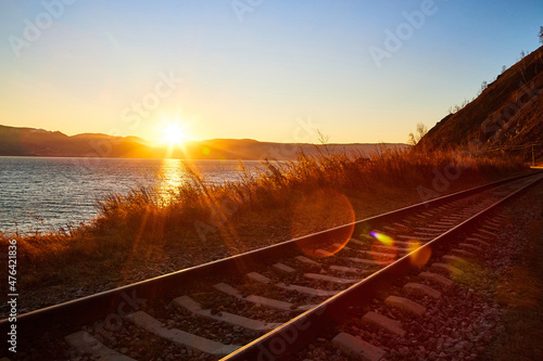 Circum Baikal railway running along the shore of Lake Baikal on an autumn sunny day with a yellow landscape around
