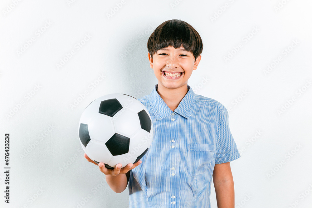 Happy smile Mix race preteen sports boy in school uniform holding a black and white soccer ball isolated on white background. Young kid soccer player, kids activities, little footballer concept ideas Happy smile Mix race preteen sports boy in school uniform holding a black and white soccer ball isolated on white background. Young kid soccer player, kids activities, little footballer concept ideas