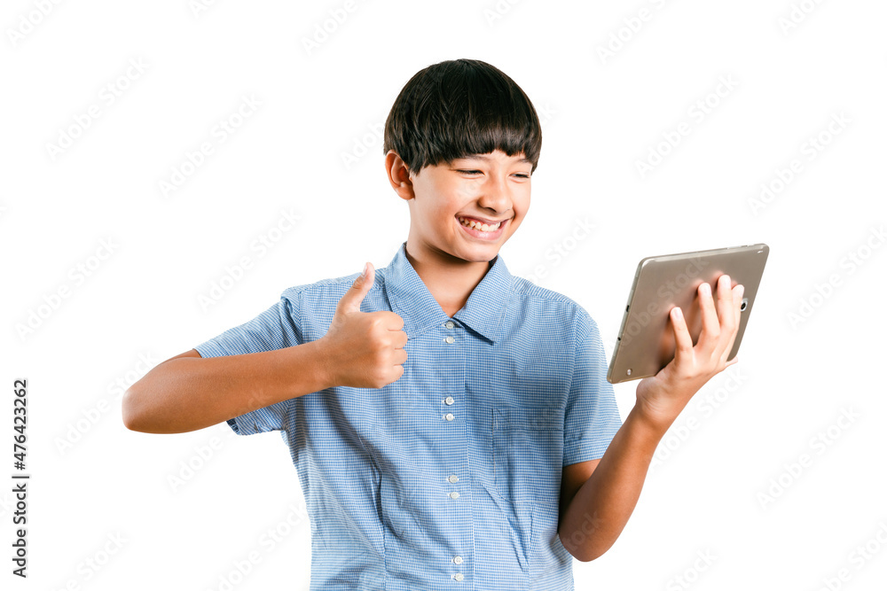 Preteen mix race boy kid in school uniform using a tablet computer mobile to online e-learning, social media for texting chatting or play a game on white background. Child technology study concept Preteen mix race boy kid in school uniform using a tablet computer mobile to online e-learning, social media for texting chatting or play a game on white background. Child technology study concept
