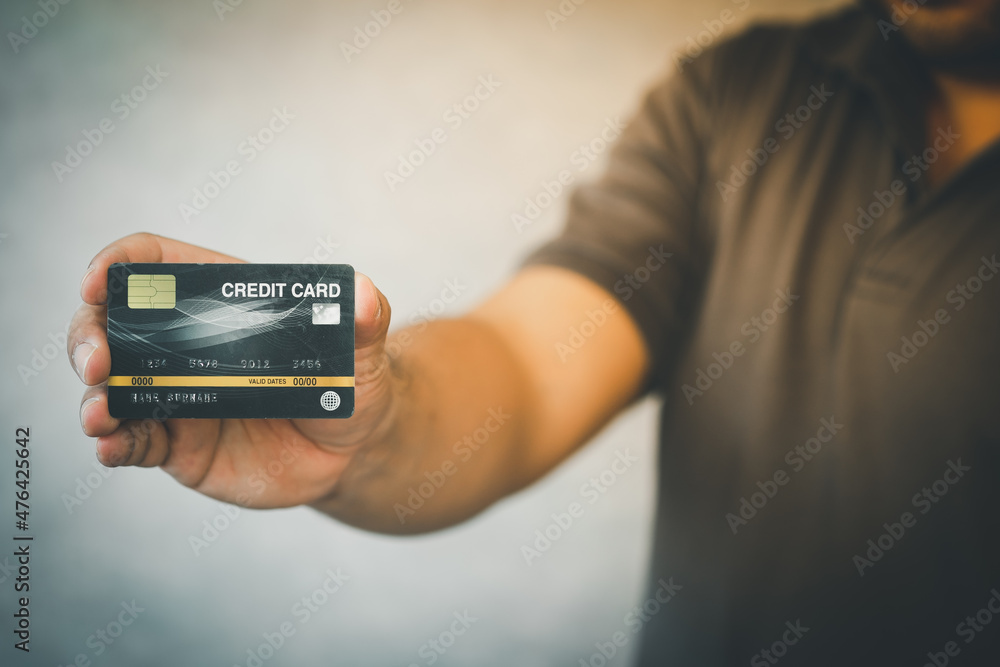 Cropped view of man holding black credit card Cropped view of man holding black credit card