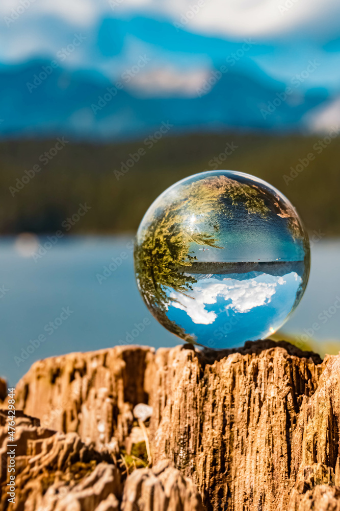 Crystal ball alpine summer landscape shot on a tree stump at the famous Eibsee lake near Garmisch-Partenkirchen, Bavaria, Germany Crystal ball alpine summer landscape shot on a tree stump at the famous Eibsee lake near Garmisch-Partenkirchen, Bavaria, Germany