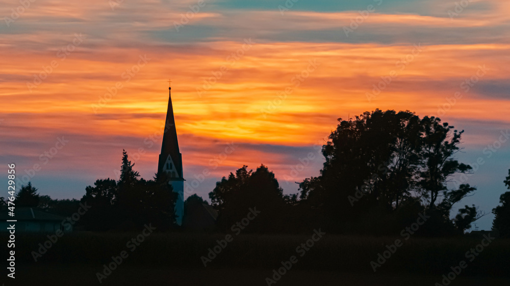 Beautiful sunset view with the silhouette of a church near Strasskirchen, Bavaria, Germany
