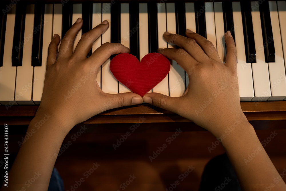Two hand hold red cartoon heart on keyboard's piano, To tell love to learn  music or to tell someone love. Stock Photo | Adobe Stock