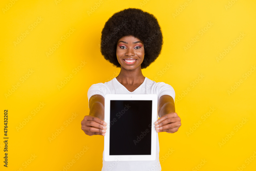 Photo of charming nice afro american young lady give you screen tablet empty space isolated on yellow color background Photo of charming nice afro american young lady give you screen tablet empty space isolated on yellow color background