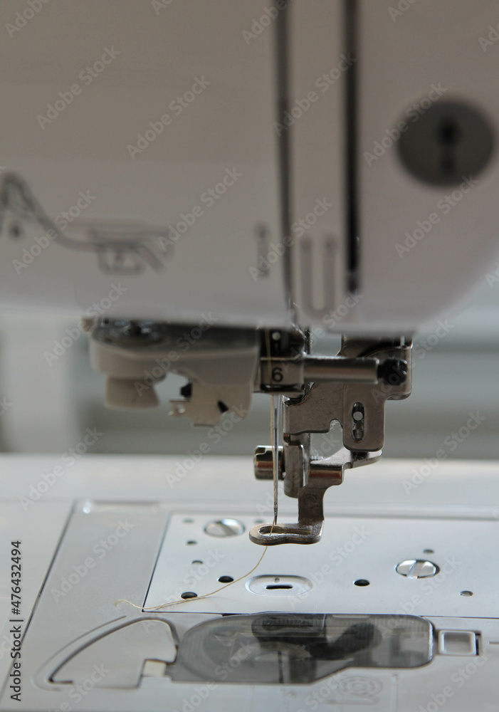 Closeup view of needle and foot of sewing machine.