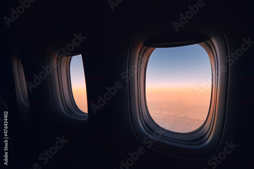 Fotografie, Obraz Windows of airplane during flight above clouods at beautiful sunrise