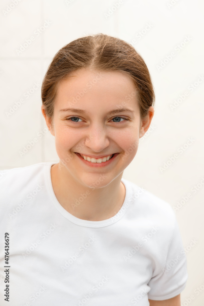 face of a teenage girl, she looks at herself in the mirror and smiling, good and clean skin is a concept of beauty and health face of a teenage girl, she looks at herself in the mirror and smiling, good and clean skin is a concept of beauty and health