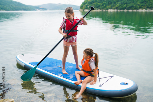Photography Children in swim life vest swimming on stand up paddle board together
