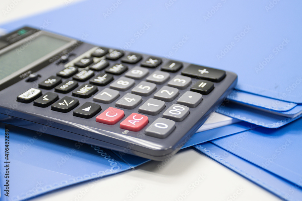 calculator with file folder on table in work office, concepts business and cost and financial planning selective focus calculator calculator with file folder on table in work office, concepts business and cost and financial planning selective focus calculator