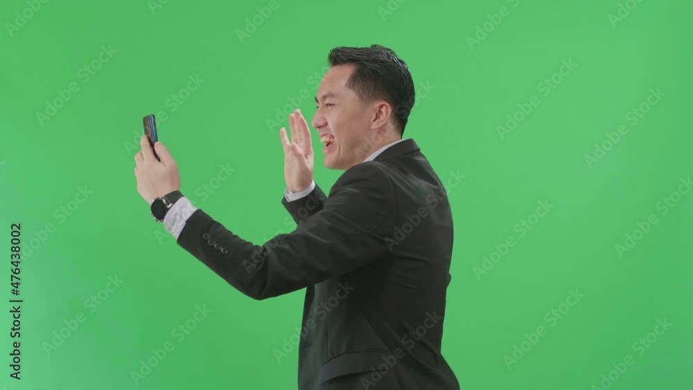 Side View Of Asian Business Man Having Video Call On Mobile Phone While Walking On Green Screen Chroma Key
Side View Of Asian Business Man Having Video Call On Mobile Phone While Walking On Green Screen Chroma Key