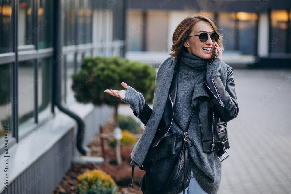 Fototapeta premium Young woman model in leather jacket outside the street
